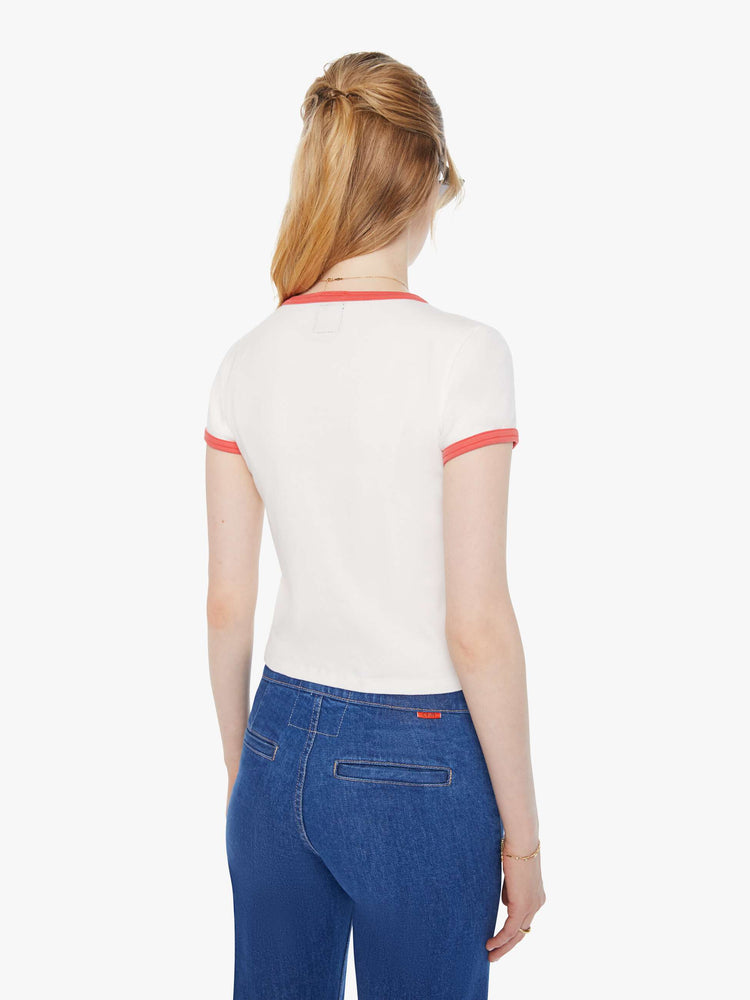 Back view of a woman in a white with faded red trim with an abstract rose graphic crewneck tee with extra-short sleeves and a cropped hem. 