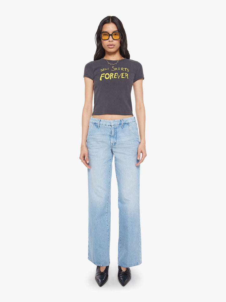 Full body view of a  faded black tee with a Mini Skirts Forever features yellow text on the front.