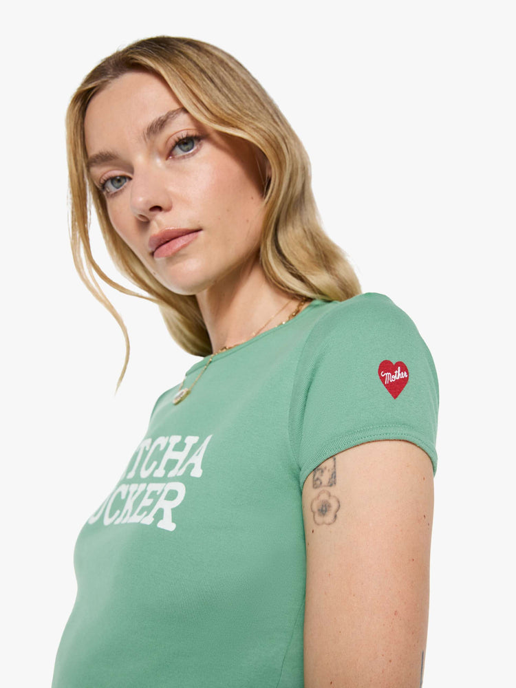 Clos up of shoulder view matcha green tee features an explicit text graphic in white on the front.
