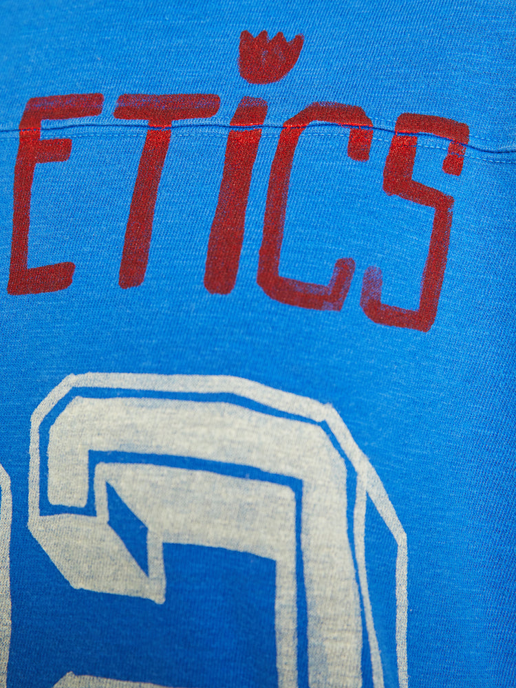 Swatch view of a women football tee with a boat neck, 3/4 sleeves, drop shoulders and a boxy fit in blue with number 32 and text in red.