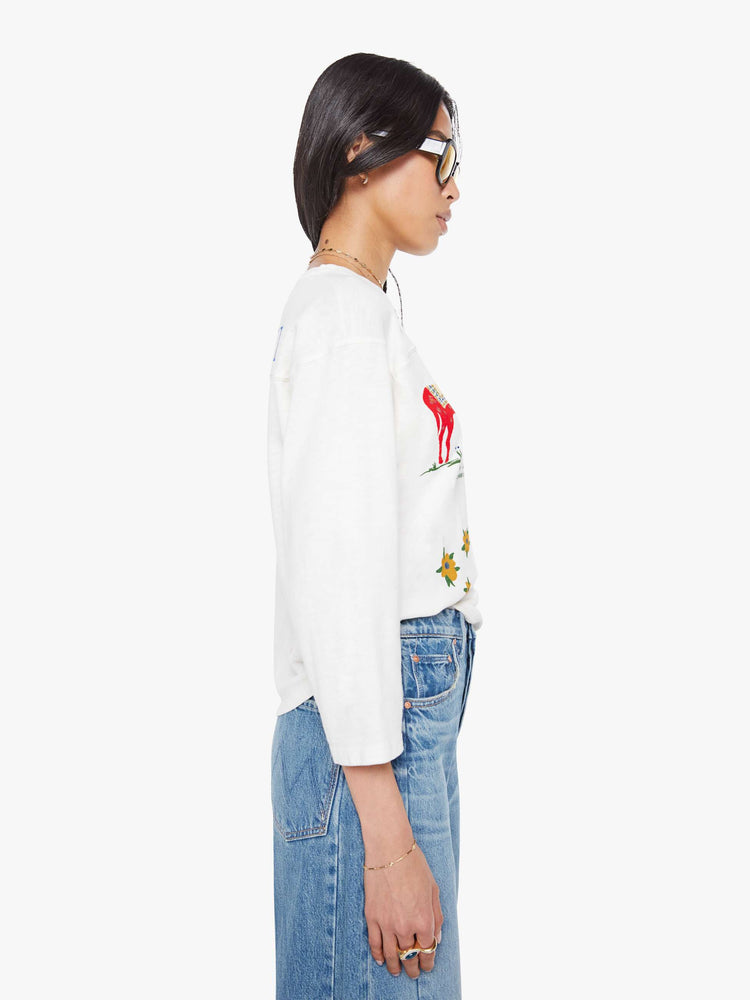 Side view of a woman in horse and flower white oversized crewneck tee is designed with drop shoulders, 3/4 sleeves and a boxy fit.