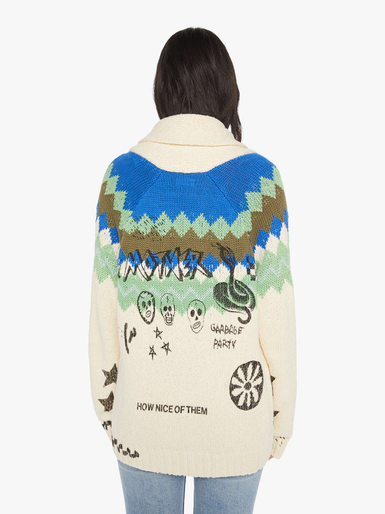 Back view of a woman cardigan with a shawl collar, patch pockets, extra-long hems and buttons down the front in cream with a traditional knit pattern across the shoulders and angsty hand-drawn doodles inspired by bathroom graffiti.