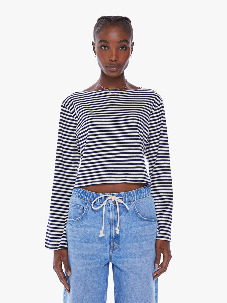 Front view of a woman navy and white stripe  boatneck top with long sleeves, drop shoulders, a cropped hem and boxy fit.