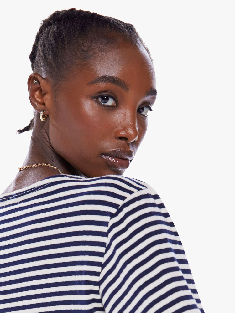 Close up view of a woman navy and white stripe boatneck top with long sleeves, drop shoulders, a cropped hem and boxy fit.