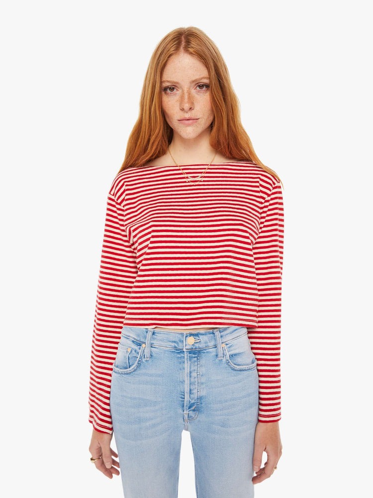 Front view of a woman red and white stripe pattern boatneck top with long sleeves, drop shoulders, a cropped hem and boxy fit.
