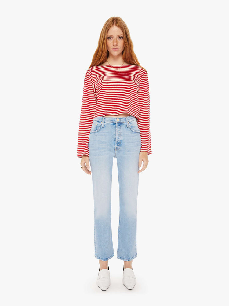Full body view of a woman red and white stripe pattern boatneck top with long sleeves, drop shoulders, a cropped hem and boxy fit.