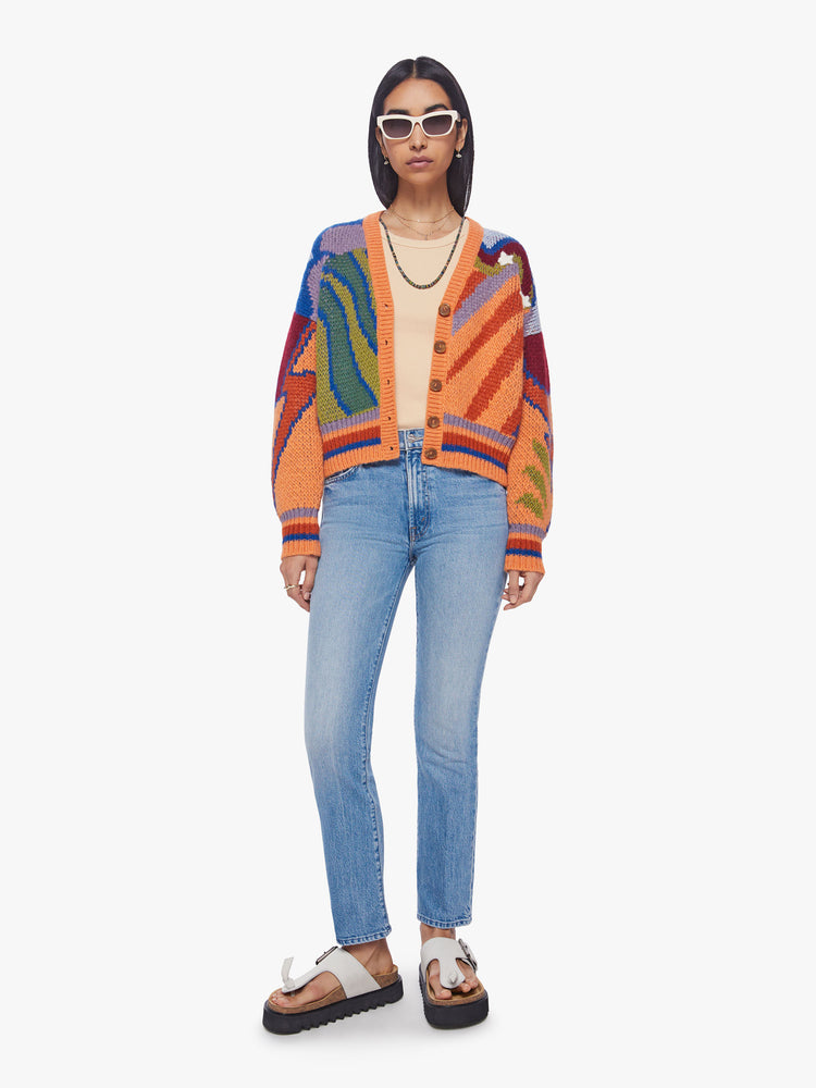 Front view of woman chunky knit cardigan, ribbed hems and a deep V-neck with buttons down the front in a colorful psychedelic print.