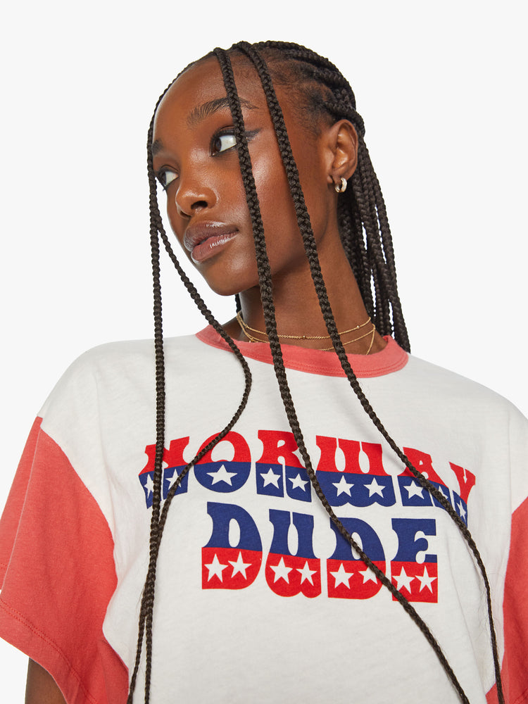 Close up view of a women oversized cropped tee with drop shoulders, subtle bat wings and a boxy fit in a white with faded red sleeves and trim, the top features a Western-inspired text graphic on the front.
