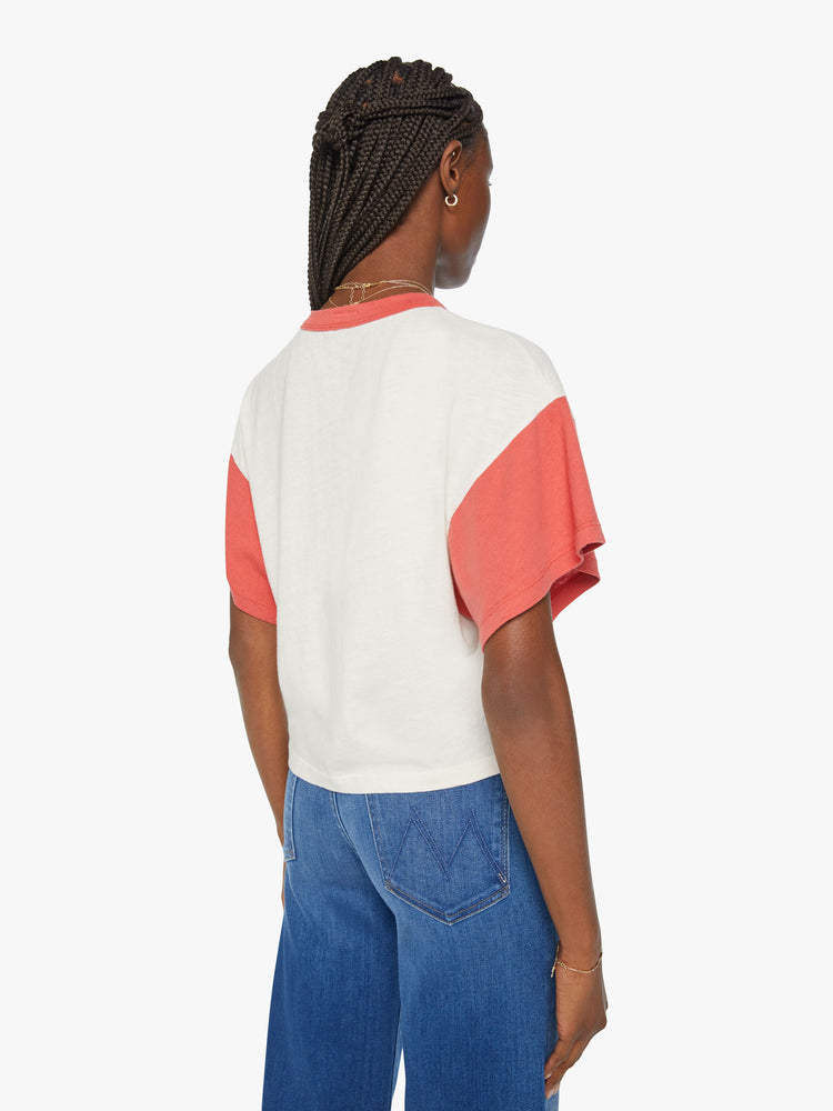 Back view of a women oversized cropped tee with drop shoulders, subtle bat wings and a boxy fit in a white with faded red sleeves and trim, the top features a Western-inspired text graphic on the front.