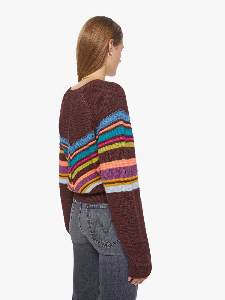 Back view of a woman raglan sweater with a crewneck, extra-long sleeves and a slightly cropped hem in a maroon hue with colorful stripes and eyelet details.
