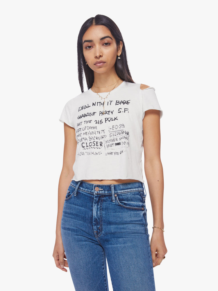 Front view of a woman cropped crewneck tee with a raw hem and ripped shoulder seam in white with the tee features a hand-drawn coming-to-terms text graphic in black on the front.