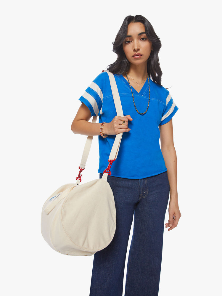 Front view of a woman blue with white stripes on the sleeves football tee with a a V-neck with a seamed detail across the chest, short sleeves, drop shoulders.