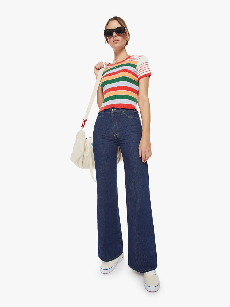 Full body view of a woman rainbow stripe scoop neck tee with short sleeves, a slim fit and a cropped hem.