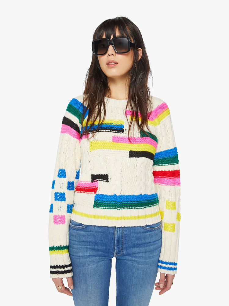 Front view of a woman crewneck sweater in an off-white with colorful stripes, checks and cable knits details.