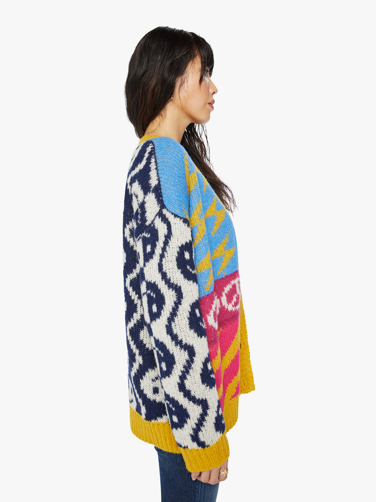 Side view of a woman oversized V-neck cardigan with drop shoulders, long balloon sleeves and ribbed hems in graphic smiley faces, peace signs, lightning bolts and zebra print.