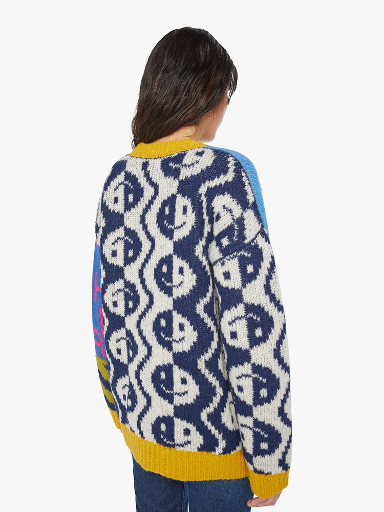 Back view of a woman oversized V-neck cardigan with drop shoulders, long balloon sleeves and ribbed hems in graphic smiley faces, peace signs, lightning bolts and zebra print.
