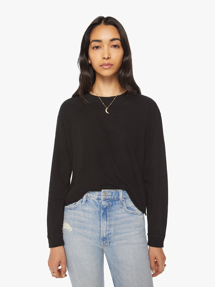 Front view of a womens long sleeve crew neck tee in Black featuring a cropped raw cut hem.
