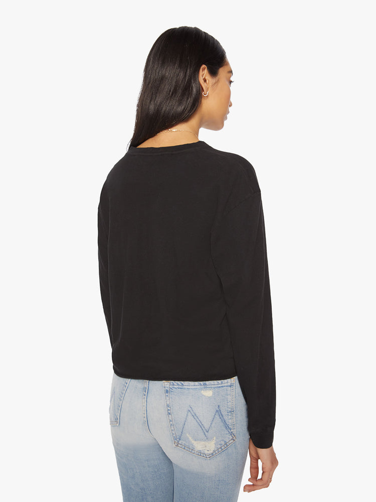 Back view of a womens long sleeve crew neck tee in Black featuring a cropped raw cut hem.
