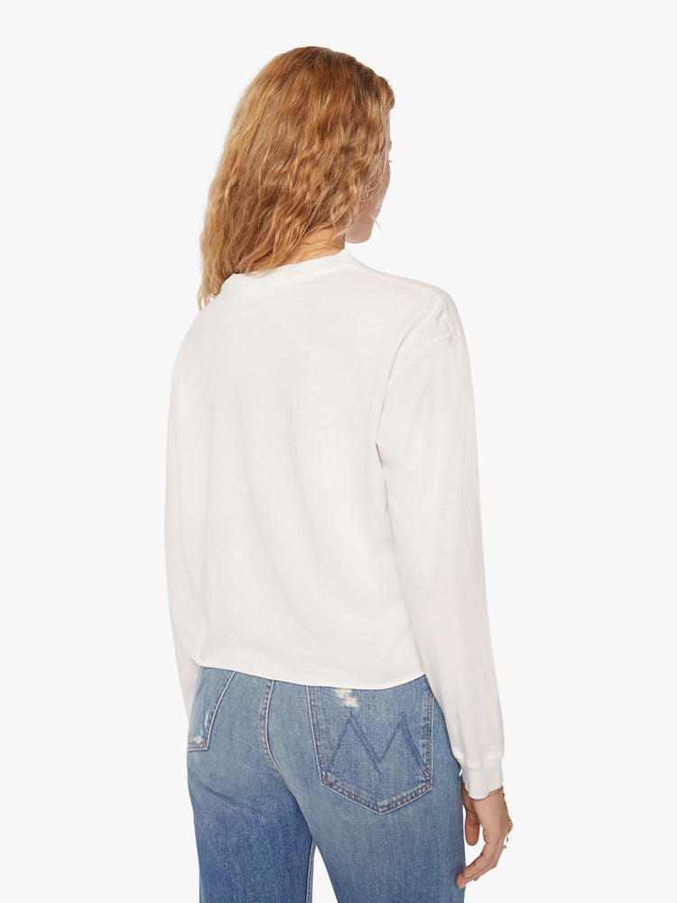 Back view of a womens white crew neck shirt featuring cuffed long sleeves and a raw cropped hem.