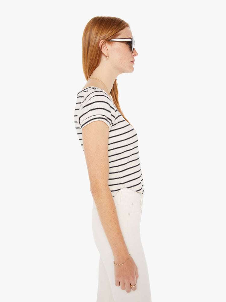 Side view of a womens black and white striped fitted scoop neck tee featuring a curved hem.