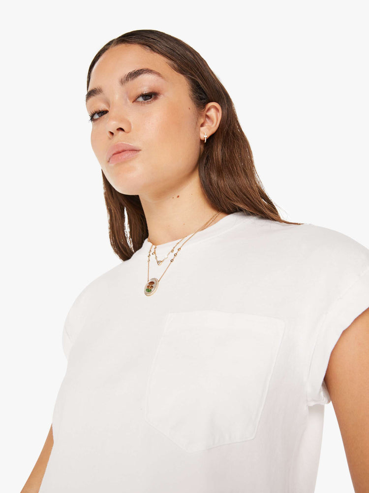 Front close up view of a womens white crew neck tee featuring a cropped body and chest pocket.
