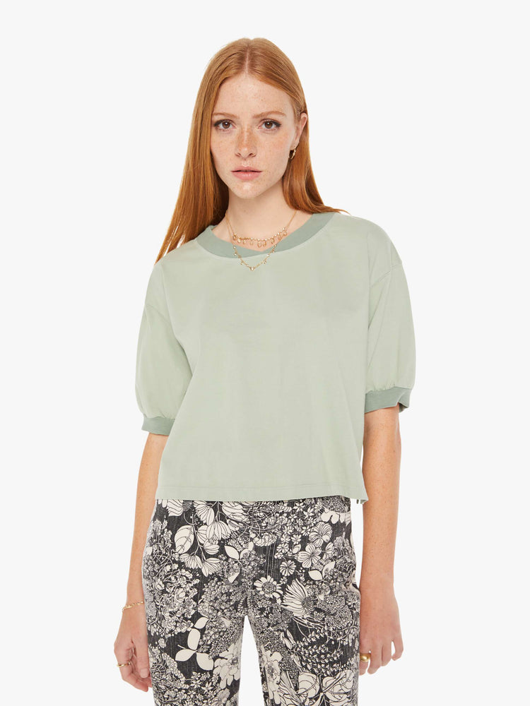 Front view of a womens faded green shirt featuring ribbed hems and puff sleeves.