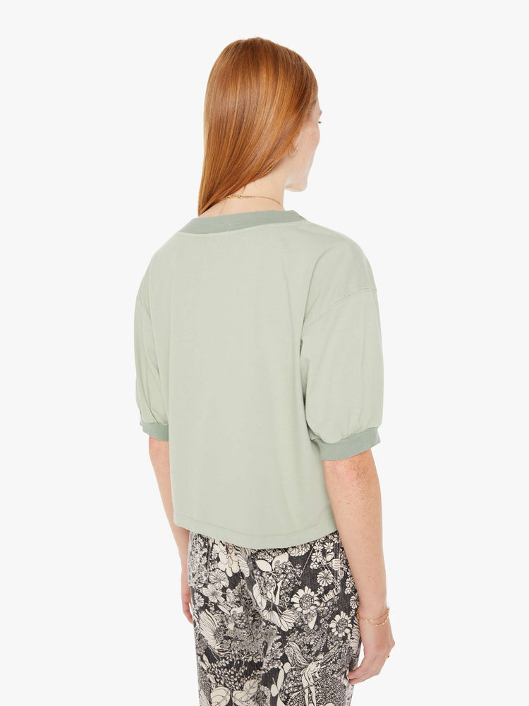 Back view of a womens faded green shirt featuring ribbed hems and puff sleeves.
