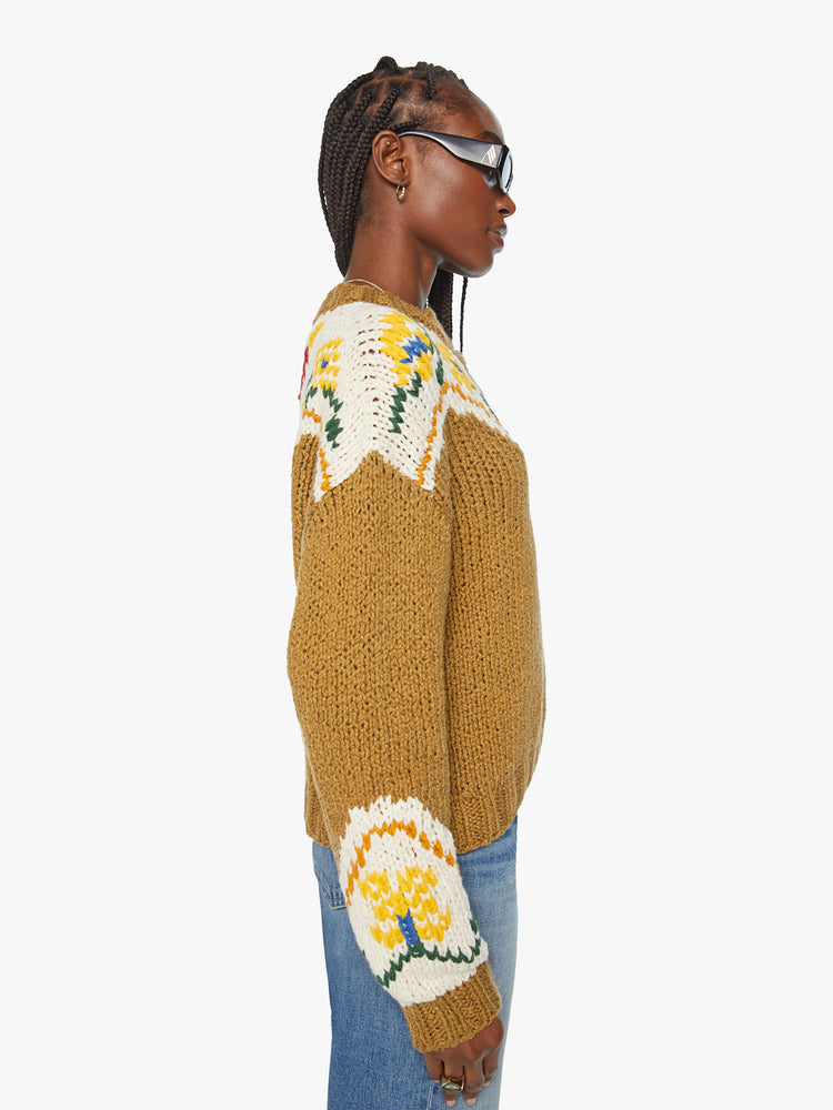 Side view of a woman chunky knit sweater with a buttoned crew neck, drop shoulders and ribbed hems in a mustard yellow with floral details and a red bull on the back.