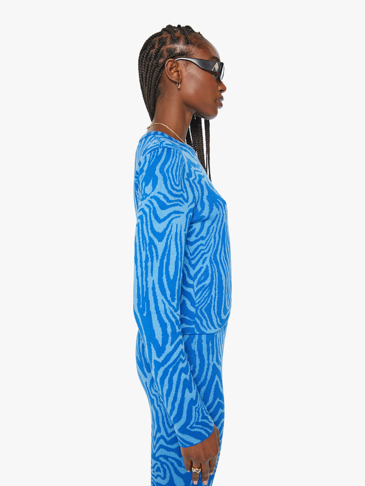 Side view of a woman long sleeve crewneck with a cropped, slightly shrunken fit in tonal blue graphic zebra print.
