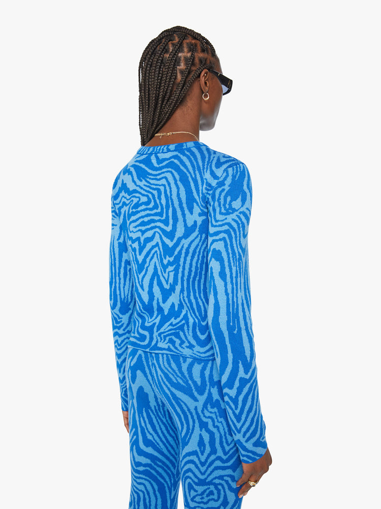 Back view of a woman long sleeve crewneck with a cropped, slightly shrunken fit in tonal blue graphic zebra print.