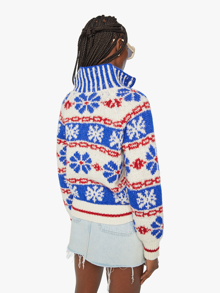 Back view of a woman chunky knit sweater with a buttoned funnel neck, subtle balloon sleeves and a slightly cropped fit in a white, red and blue traditional Nordic snowflake pattern.