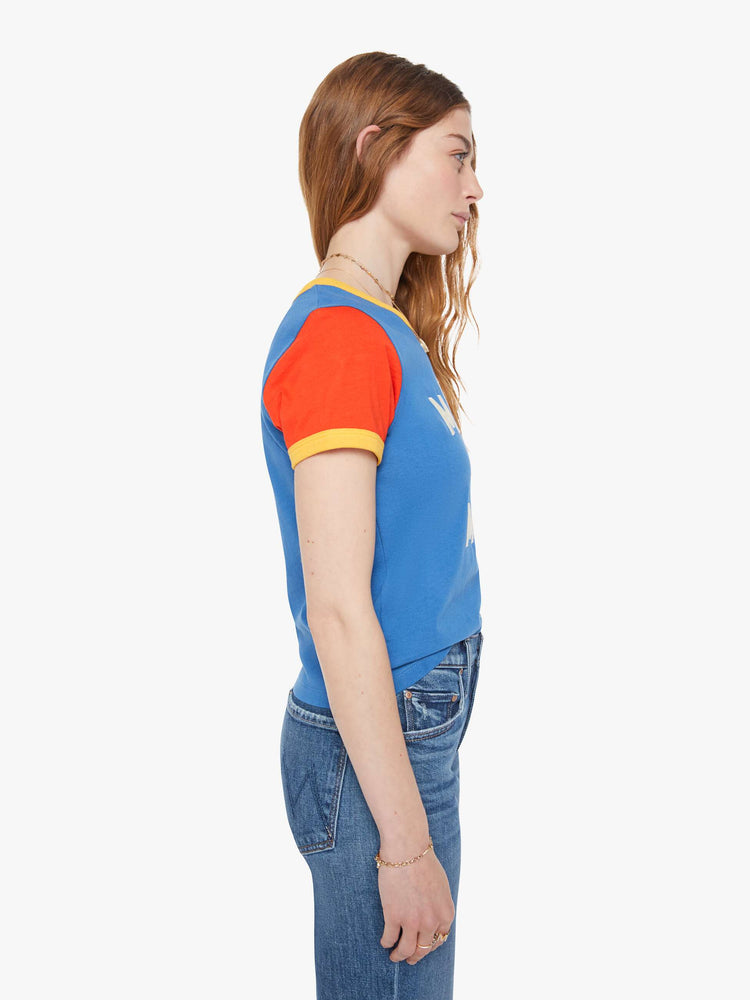 Side  view of a woman in blue crewneck tee with extra-short sleeves and a cropped hem and yellow trim.