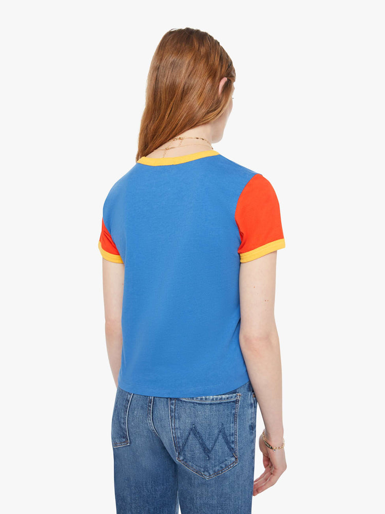 Back  view of a woman in blue crewneck tee with extra-short sleeves and a cropped hem and yellow trim.