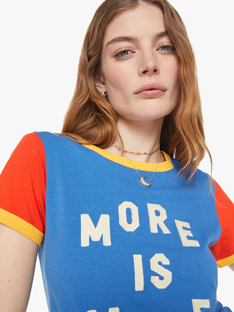Close up  view of a woman in blue crewneck tee with extra-short sleeves and a cropped hem and yellow trim.