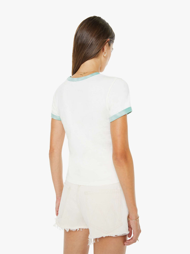 Back view of a woman in a white with green trim tee with a flocked graphic on the front inspired by a rafting expedition logo.