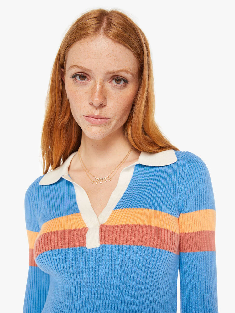 Close up view of a woman blue with orange stripes collared blouse with a V-neck, elbow-length sleeves and a narrow fit.