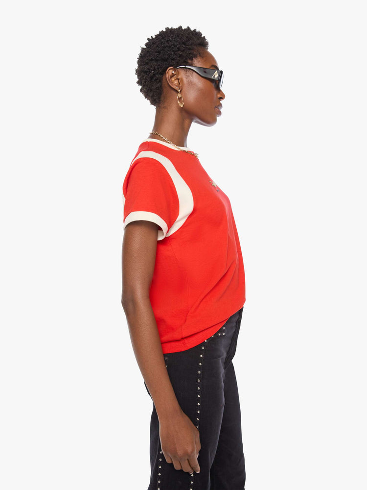 Side view of a woman in a red tee features a small cheetah graphic and MOTHER's name in blue across the front.