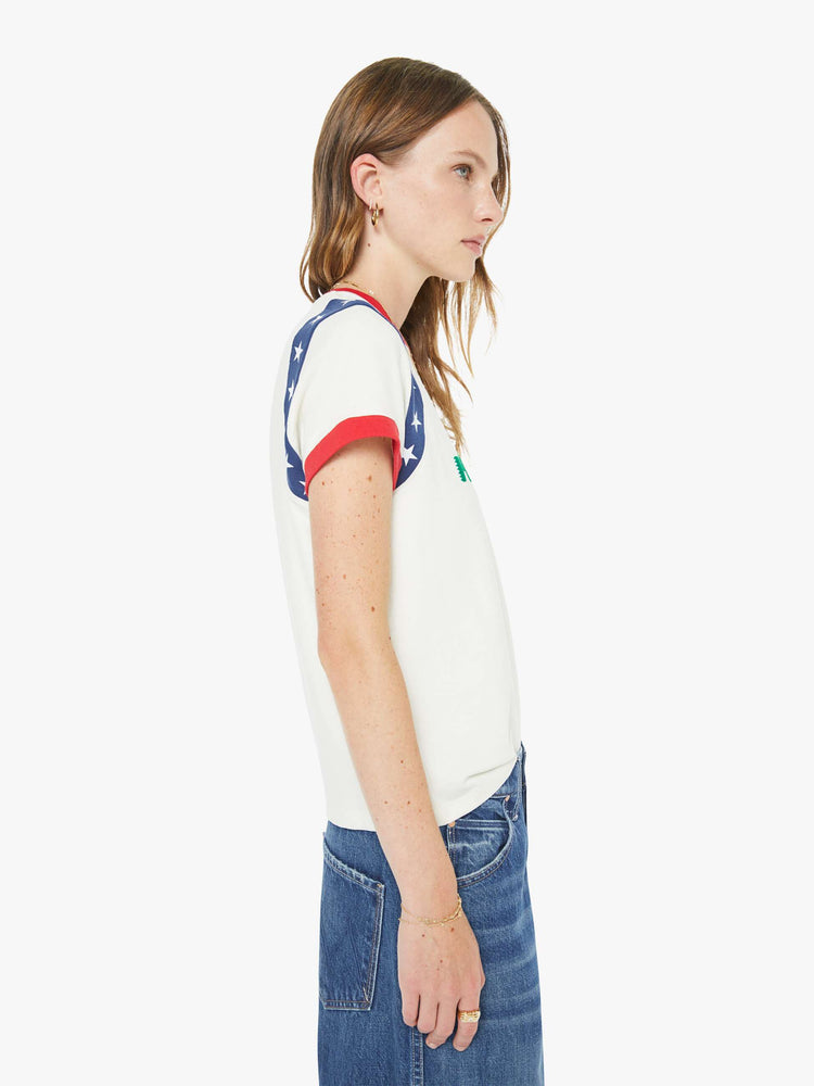 Side view of a woman in an off-white, the tee with white stars along the sleeves, red trim and MOTHER's name in green across the front — finished with a raised, velvety flocked texture.