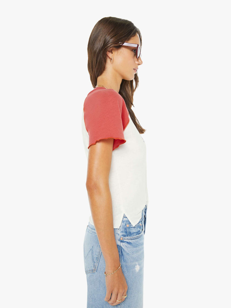 Side view of a woman in a white tee with faded red sleeves and an airbrushed water skiing graphic on the front.