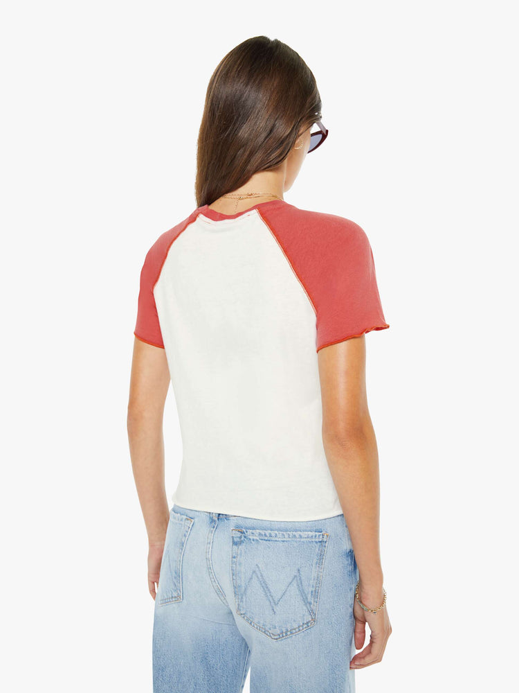 Back view of a woman in a white tee with faded red sleeves and an airbrushed water skiing graphic on the front.