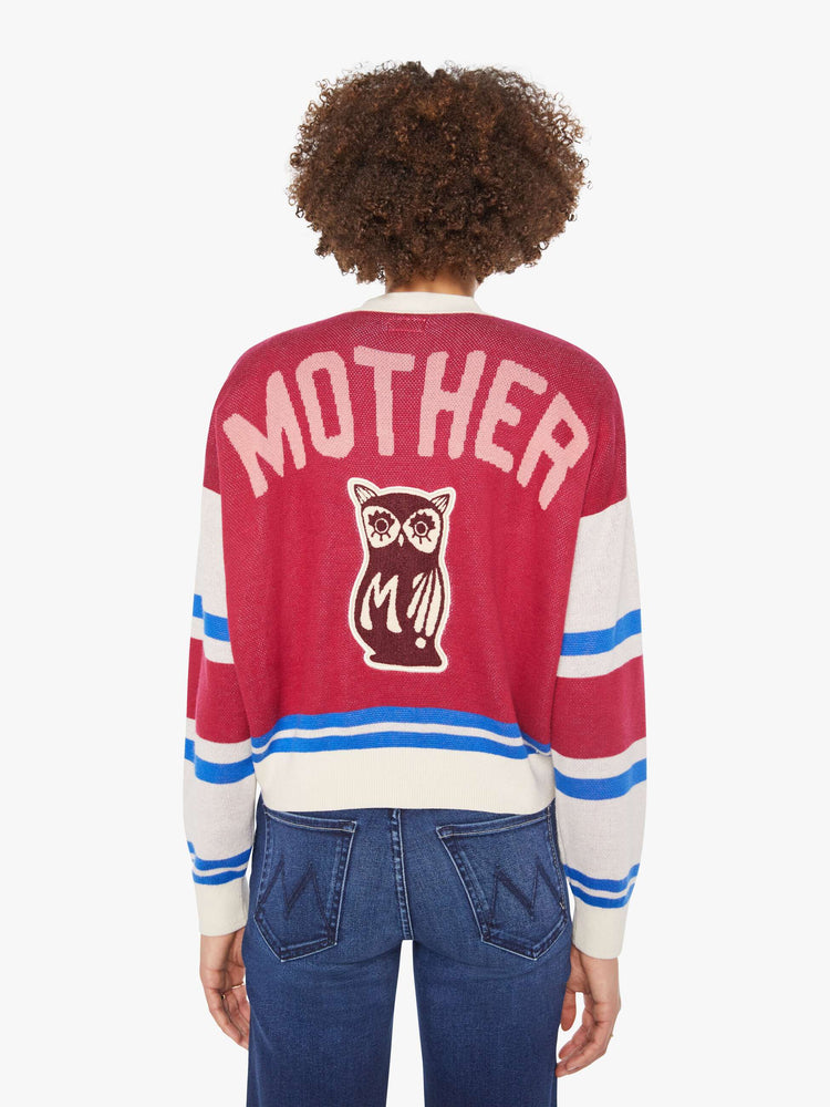 Back view of a woman in a faded red with athletic-inspired stripes across the sleeves  V-neck cardigan with drop shoulders.