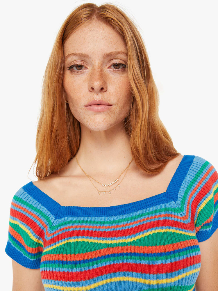 Close up view of a woman rainbow of primary colors square neck, slightly off-the-shoulder short sleeves and a narrow fit.