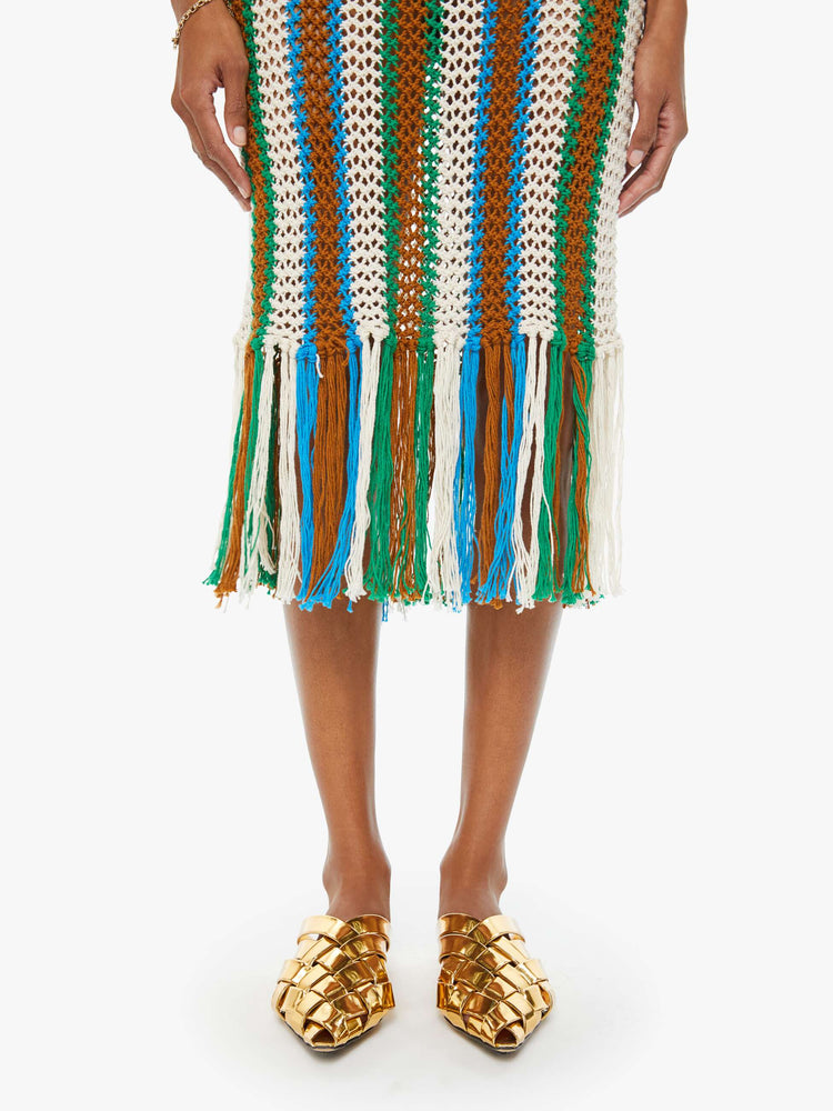 Hemline swatch view of a woman in a sleeveless vertical multi-colored striped midi dress with a scoop neck, narrow fit and fringed hem.
