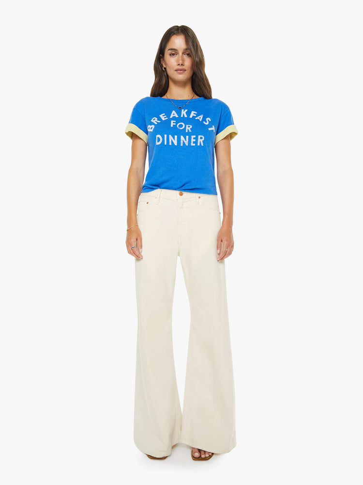 Front full body view of a womens blue tee in a cropped boxy fit featuring a white graphic and a yellow rolled cuff sleeve.