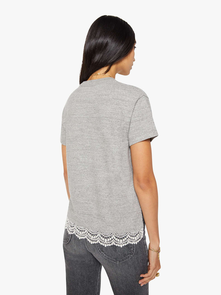 Back view of a woman in a heather grey with white lace applique on the front and lace trim oversized crewneck tee is designed with drop shoulders, short sleeves and a boxy fit.