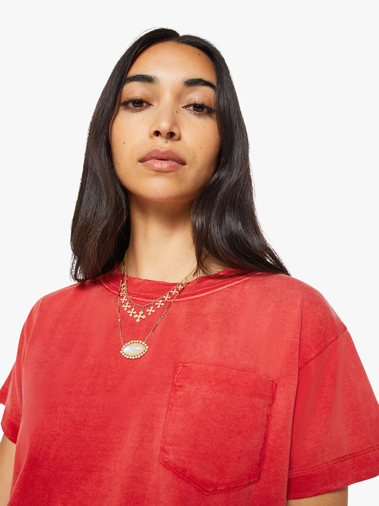 Close up view of a woman in a red top with sun-fading across the chest and shoulders.