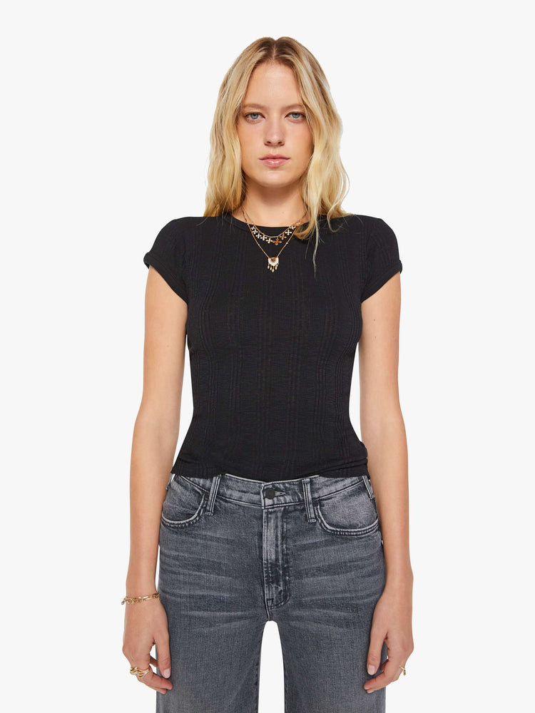Front view of a woman in a black tee with extra-short sleeves and a narrow fit.