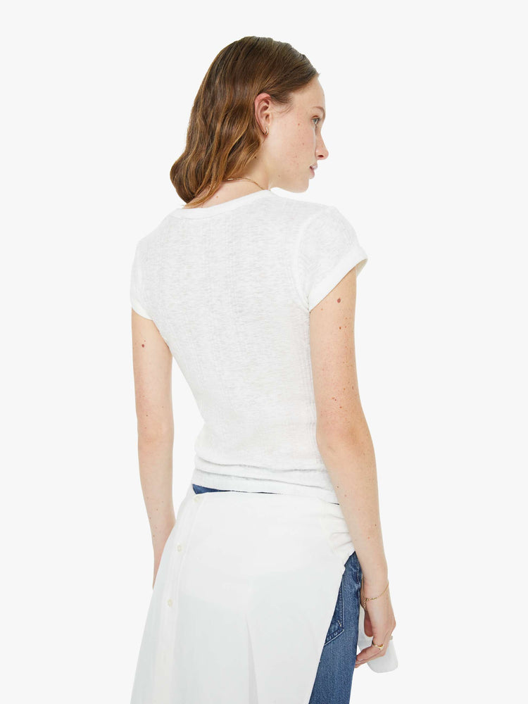 Back view of a woman in a white  shrunken crewneck tee with extra-short sleeves and a narrow fit. 