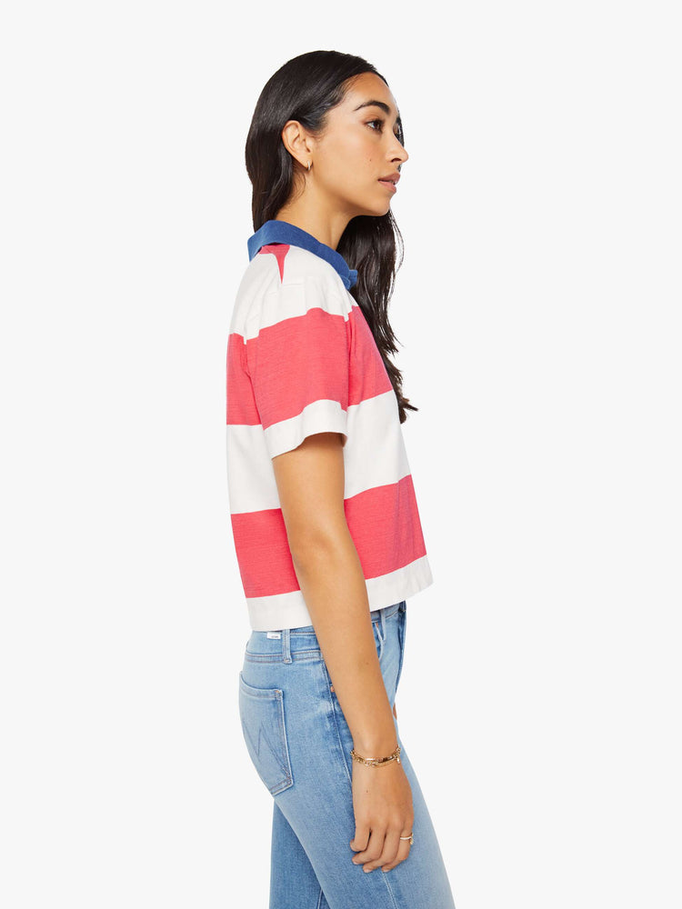 Side view of a woman in a collared top with short sleeves, a V-neck and a loose fit.