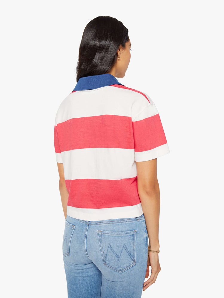 Back view of a woman in a collared top with short sleeves, a V-neck and a loose fit.